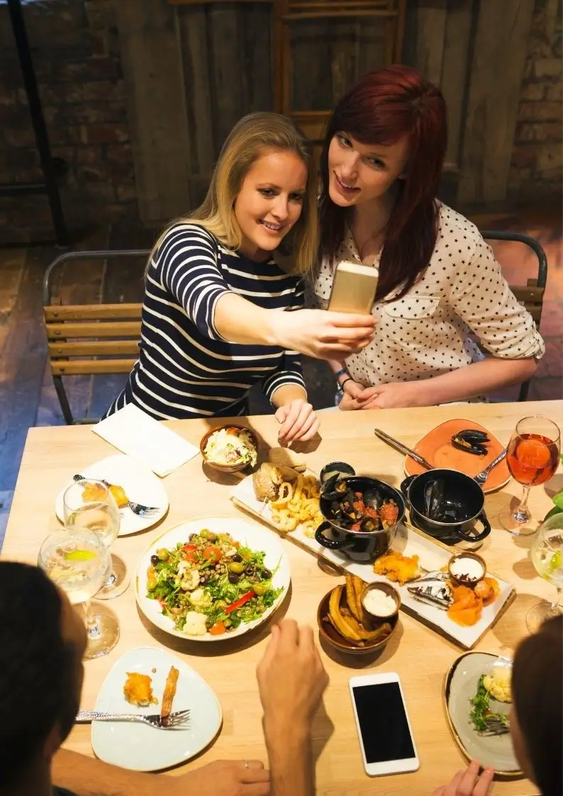 Two women taking selfie in restaurant