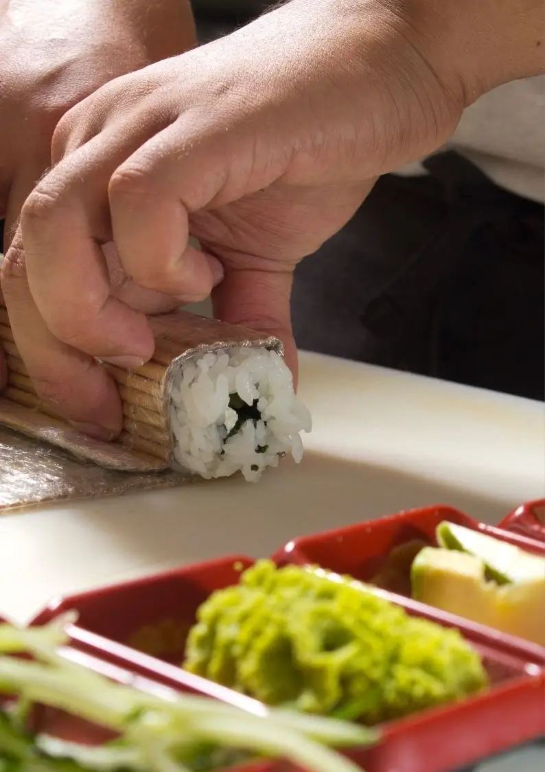 Person rolling a sushi